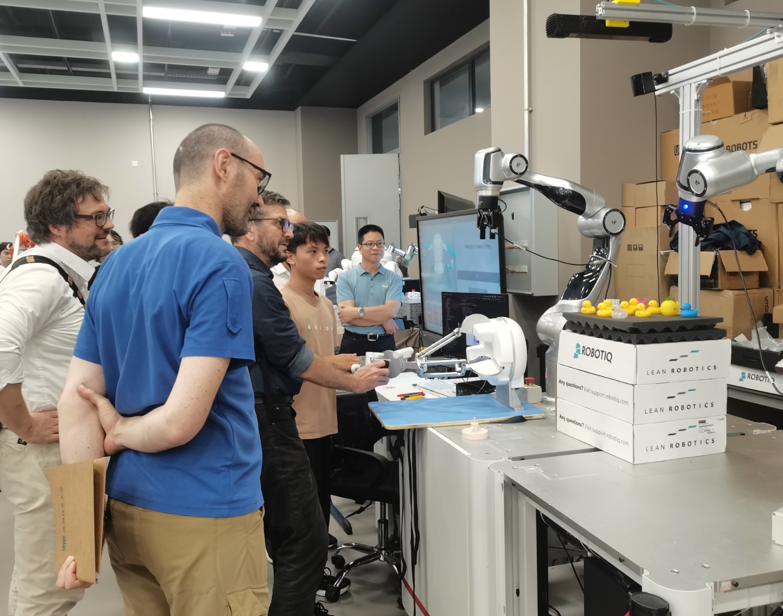 Visitors watching a robotic manipulation demonstration